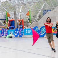 2 Männer lassen in der Glashalle der Leipziger Messe Drachen steigen.