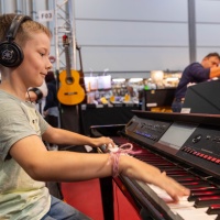 Ein Junge spielt aud einem E-Keyboard.