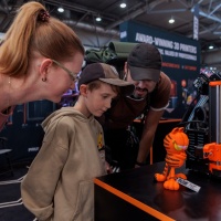 Eine Familie schaut sich eine 3D gedruckte Figur an.