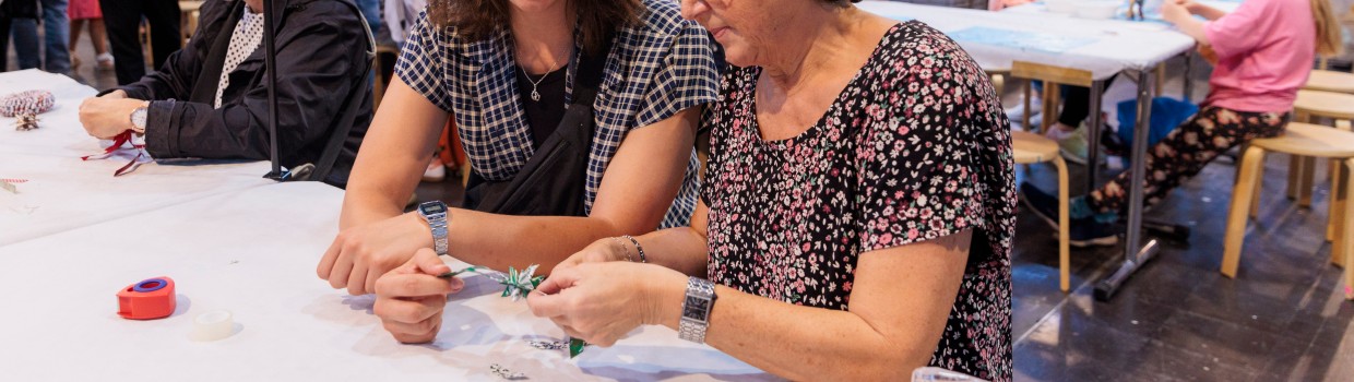 2 Frauen basteln an Rüschen.