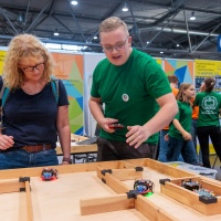 Ein Mann erklärt einen Frau Roboterautos.