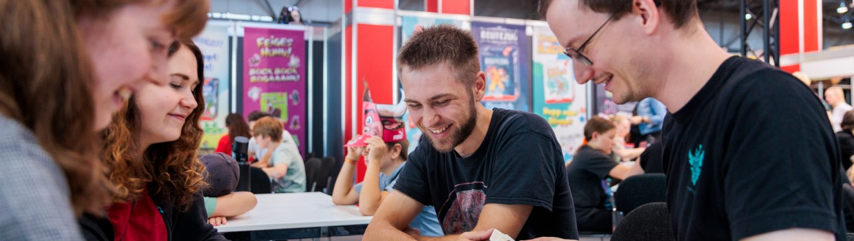 Eine Gruppe an Freunden spielt ein Kartenspiel.