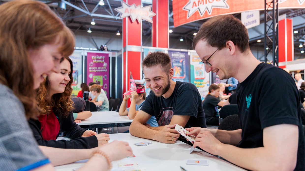 Eine Gruppe an Freunden spielt ein Kartenspiel.