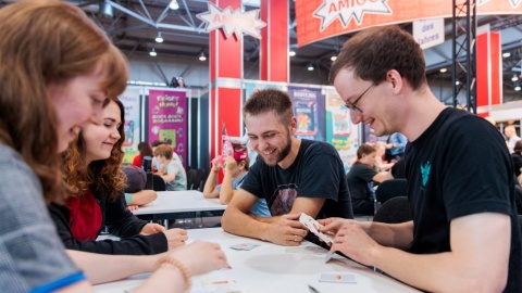 Eine Gruppe an Freunden spielt ein Kartenspiel.