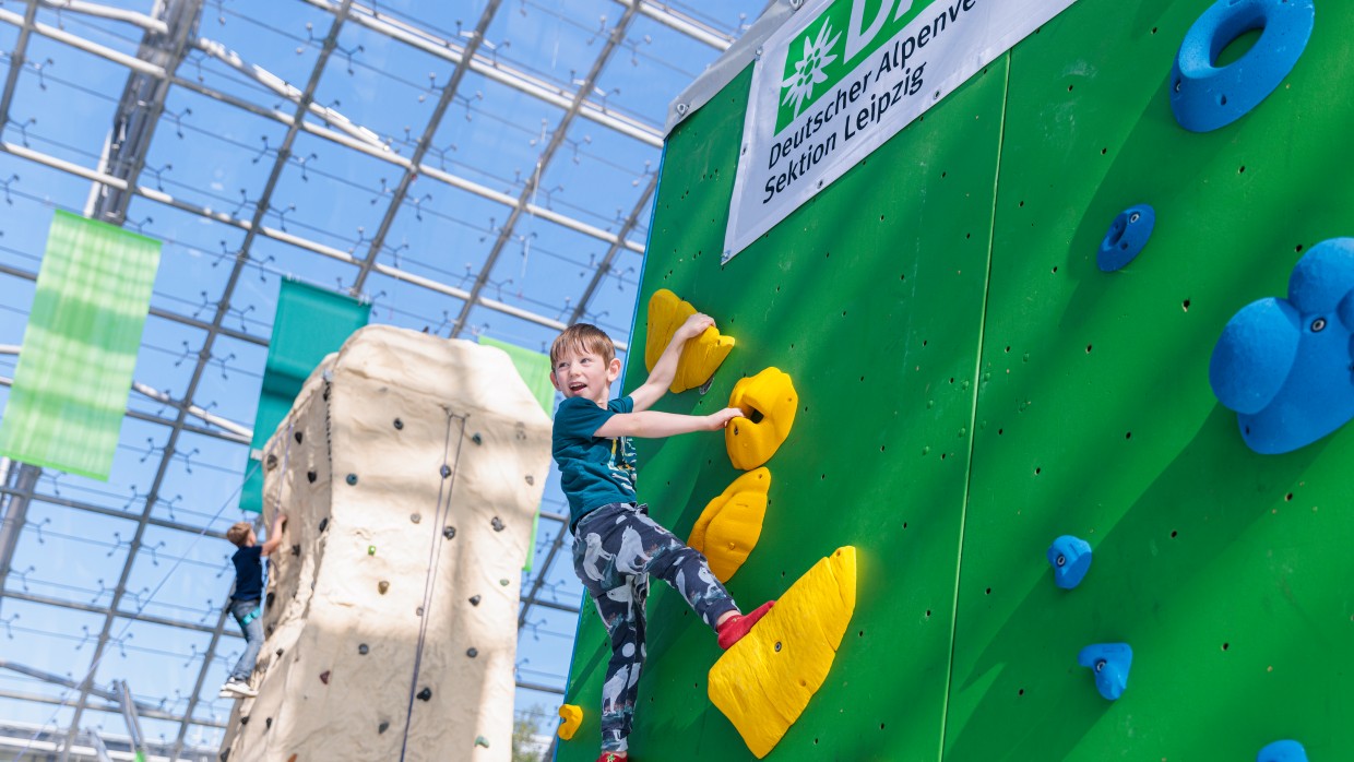 Ein Junge klettert an einer Kletterwand hoch. Ein Junge klettert an einer Kletterwand hoch.