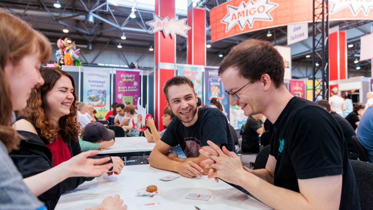 Eine Gruppe an Freunden spielt ein Kartenspiel. Eine Gruppe an Freunden spielt ein Kartenspiel.