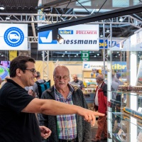 Zwei Männer schauen sich Modelleisenbahnen an. Einer zeit auf eine Modelleisenbahn.