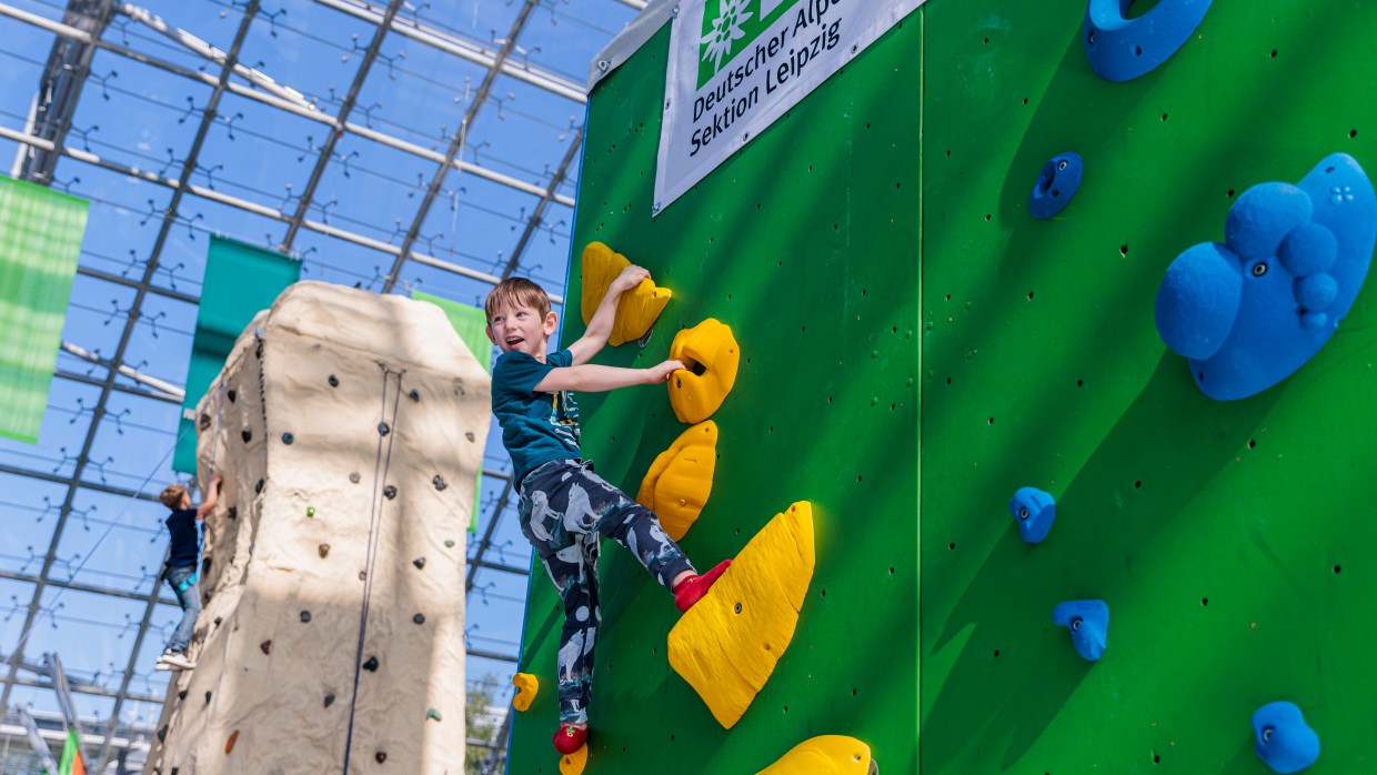 Ein Kind klettert an einer Wand hoch. Ein Kind klettert an einer Wand hoch.