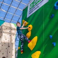 Ein Kind klettert an einer Wand hoch.